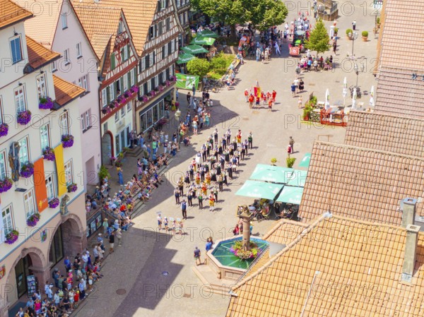 People on a square with a fountain, surrounded by decorated buildings, 950 years Calw, parade Calw, Black Forest, Germany