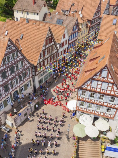 A colourful event with lots of balloons and people between historic half-timbered houses, 950 years of Calw, Calw parade, Black Forest, Germany