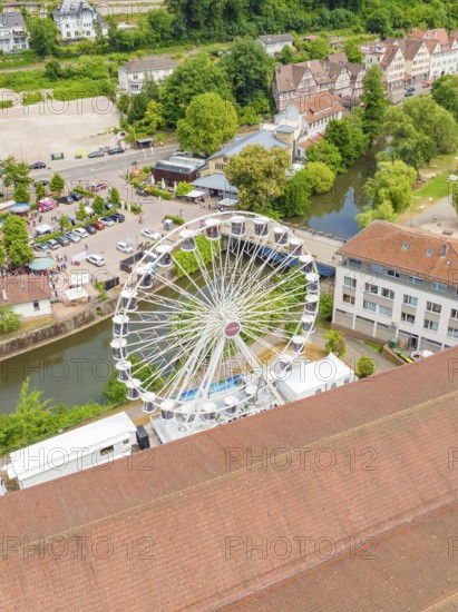 Large Ferris wheel in a park-like area next to a river, surrounded by buildings, 950 years of Calw, Calw parade, Black Forest, Germany