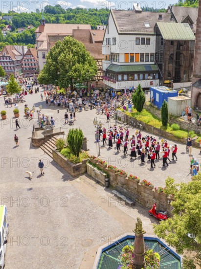 A parade moves through a market square, surrounded by half-timbered houses and many spectators in summer, 950 years of Calw, Calw parade, Black Forest, Germany