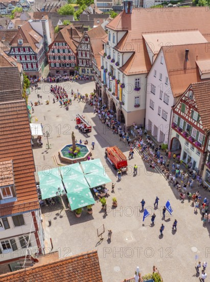 Viewed from above, a parade passes half-timbered houses around a central fountain, 950 years of Calw, Calw parade, Black Forest, Germany