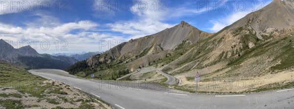 Northern ascent mountain road alpine road with serpentines above tree line shortly in front of pass summit of alpine pass Col d Izoard, Cervières, Department Hautes-Alpes, Provence-Alpes-Cote d'Azur, France