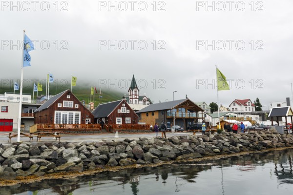 Old wooden houses with church, fishing village at Skjalfandi Bay, rain clouds, Husavik, Húsavík, North Iceland, Iceland