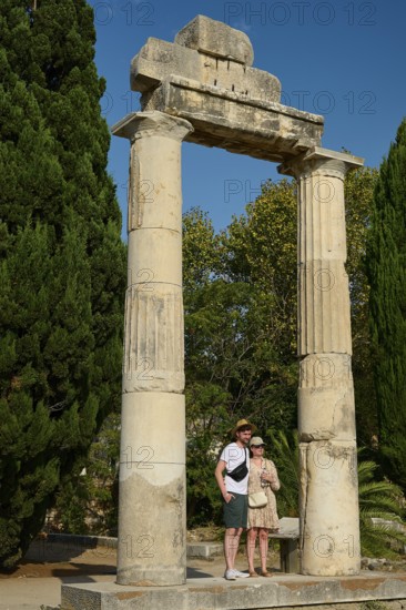 Two people posing in front of ancient columns and green trees, Ancient Agora, Kos Town, Kos, Dodecanese, Greek Islands, Greece