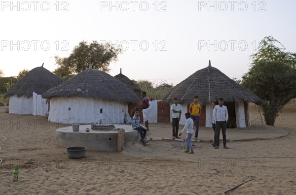 Indian desert dwellers, behind typical circular buildings in the Thar Desert or Great Indian Desert, near Jaisalmer, Rajasthan, India
