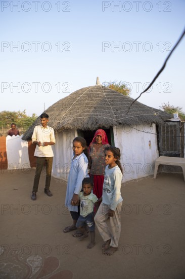 Indian desert dwellers, behind typical circular buildings in the Thar Desert or Great Indian Desert, near Jaisalmer, Rajasthan, India