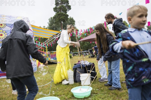 An artist makes soap bubbles with children at Kidzapalooza at the Lollapalooza Festival in the Olympiastadion and on the Maifeld, Berlin, 12 July 2025