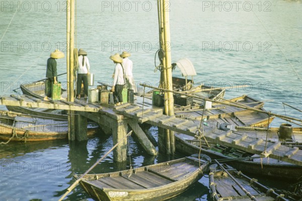 Boat dwellers with cans of water on jetty in the harbour at Aberdeen, Hong Kong, Asia 1964