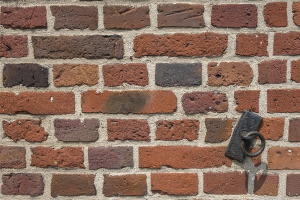 Detail of a brick wall, brick wall with a rusty metal ring, Münsterland, North Rhine-Westphalia, Germany