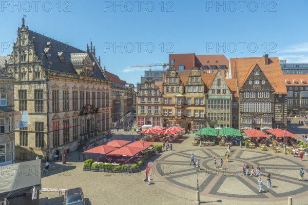 Historic market square with the Schütting House, the Chamber of Industry and Commerce (left), and the gabled houses, listed building, restaurant with sunshades, cobblestones form a circle with sectors, Old Town, Hanseatic City of Bremen, Germany