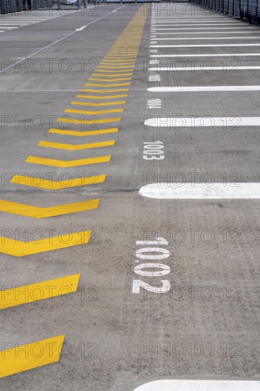 Markings on a car park deck, Direction of travel marking, Numbered parking spaces, Graphic