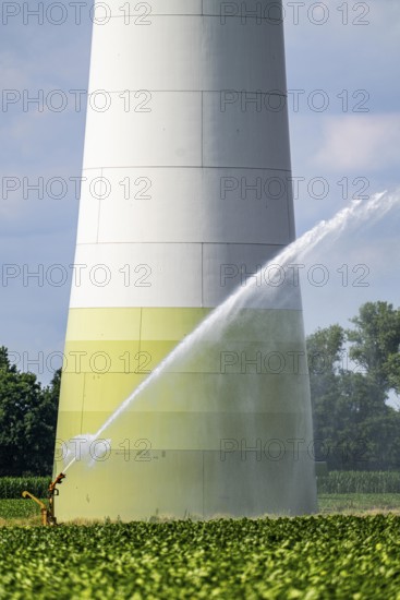 Artificial irrigation with a sprinkler system in a field where sugar beet is grown, hose reel, wind farm, west of Kerken, on the Lower Rhine, North Rhine-Westphalia, Germany