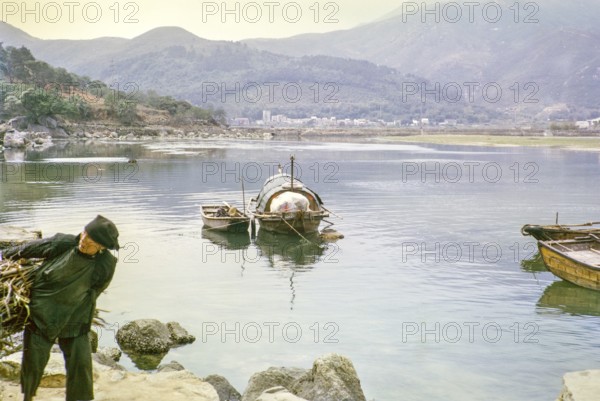 People living on sampan boats at Tai Po Hoi, New Territories, Hong Kong, Asia, 1964 woman carrying wood