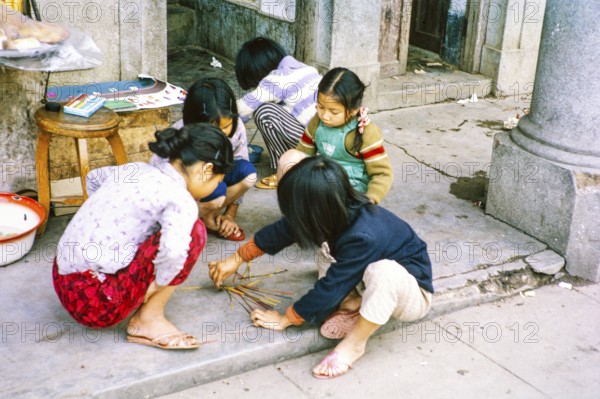 Children playing spillikins on street, Tai Po, New Territories, Hong Kong, Asia, 1964