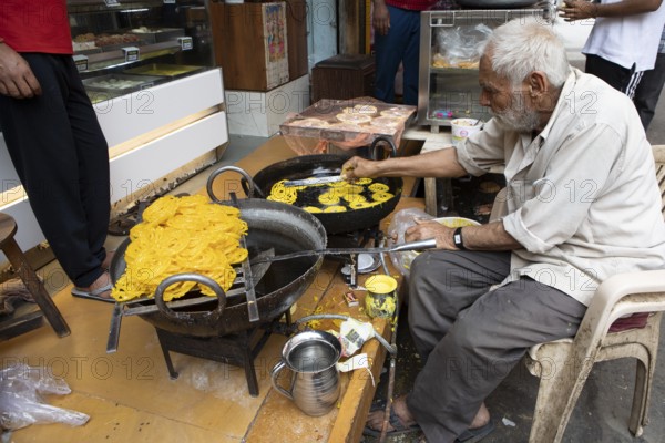 Indian man frying local sweet in the old town of Jaisalmer, Rajasthan, India