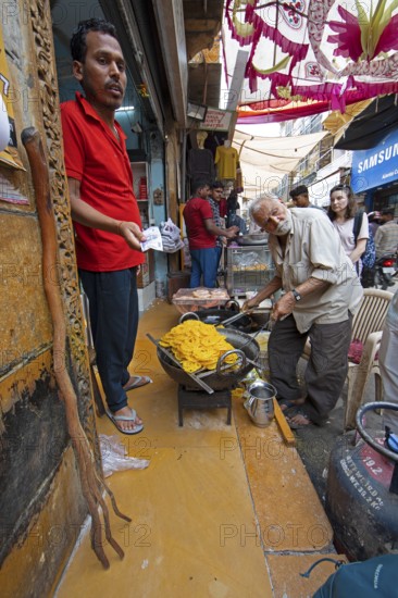 Indian man frying local sweet in the old town of Jaisalmer, Rajasthan, India
