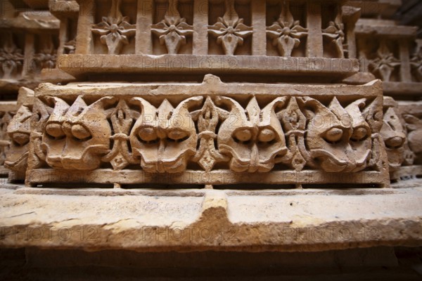 Sculptures of heads on a pillar in the Jain temple Chandraprabhu in the fortress in Jaisalmer, Rajasthan, India