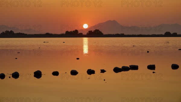 Glistening sunset with warm tones and mountain silhouette, salt lake, Tigaki, nature reserve, hydro biotope, Kos, Dodecanese, Greek Islands, Greece