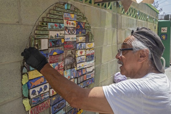 Detroit, Michigan - The city of Detroit is opening nine 'Arts Alleys' in neighborhoods around the city. Artist Vito J. Valdez makes a ceramic mural on the Bagley Arts Alley with tiles handmade by residents of the Mexican-American community
