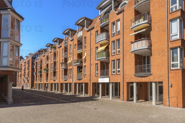 Modern brick architecture, Teerhof peninsula, columns, balconies, cobblestones, street, blue sky, Weser, Hanseatic city of Bremen, Germany