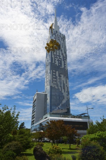 A modern high-rise building rises against a blue sky with clouds. The architecture is futuristic and urban, Batumi Tower with Ferris wheel, Batumi, Black Sea, Ajara region, Adjara, autonomous republic, Georgia