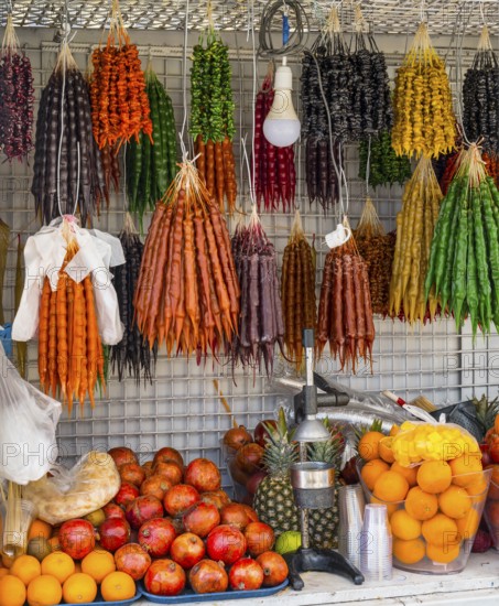 A market stall full of colorful fruits and traditional sweets with a juicer in the foreground, Churchkhela hanging, Georgian confectionery, 'Georgian snickers', Batumi, Black Sea, Ajara region, Adjara, autonomous republic, Georgia