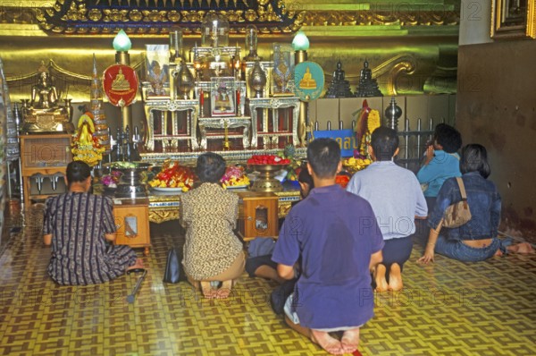People praying in the temple with the Buddha statue Phra Mongkhonbophit, Ayutthaya, Thailand, December 2002, vintage, retro, old, historic