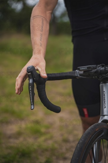 Close-up of a hand on the handlebars of a racing bike with visible tattoo, triathlon, Calw, Germany