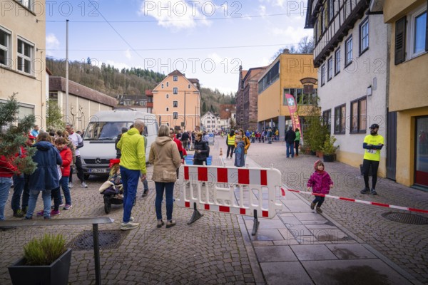 Busy street scene in the city with people talking and a roadblock, Triathlon, Calw, Germany