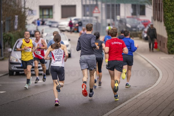 Runners in sportswear running on a street surrounded by houses, triathlon, Calw, Germany