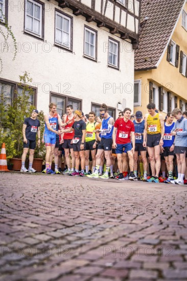 Group of runners at the starting line on a paved road in front of timber-framed houses, triathlon, Calw, Germany