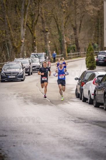 Two runners on a wooded village road with parked cars, triathlon, Calw, Germany