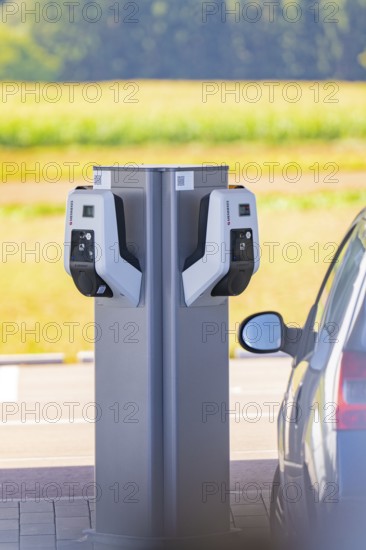 Electric car at a double charging station in a parking lot with a view of nature, e-charging park, Merklingen, Germany