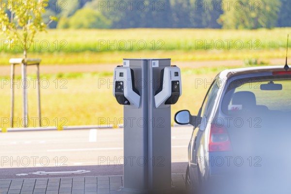 Electric vehicle at a charging station with a view of a natural landscape, e-charging park, Merklingen, Germany