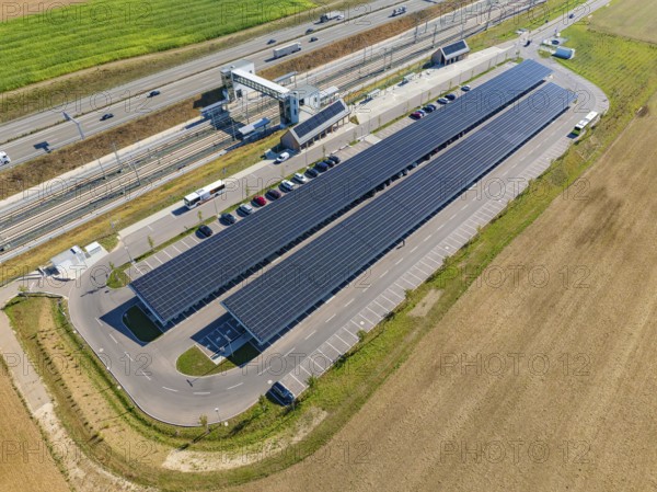 Aerial view of a parking lot with solar panels and vehicles on a street, e-charging park, Merklingen, Germany