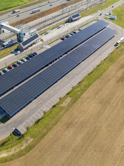 Solar system with adjacent parking spaces and parked cars under clear skies, e-charging park, Merklingen, Germany