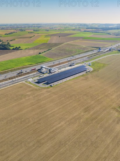 Solar system next to a motorway, surrounded by agricultural land, e-charging park, Merklingen, Germany