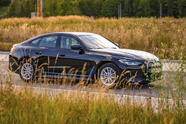 Black car on the side of the road surrounded by fields and trees, BMW i7 electric car, Deer E- Carsharing, Calw, Germany
