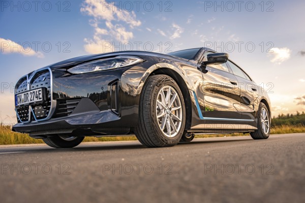 Black car on the road from a frog's eye view with blue sky, BMW i7 electric car, Deer e-Carsharing, Calw, Germany