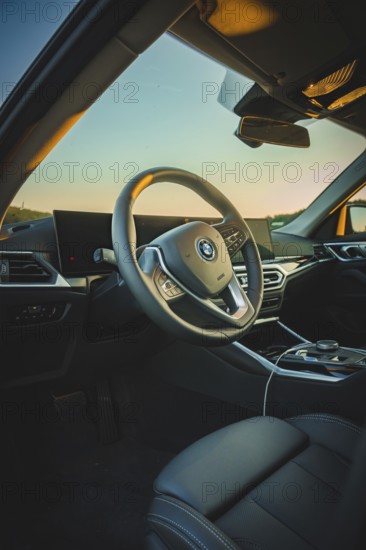 Modern car interior with stylish steering wheel and screens, in sunset light, BMW i7 electric car, Deer e-Carsharing, Calw, Germany