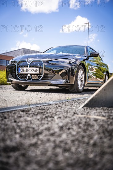 A black car is parked on a quiet road under a blue sky, BMW i7 electric car, Deer E- Carsharing, Calw, Germany