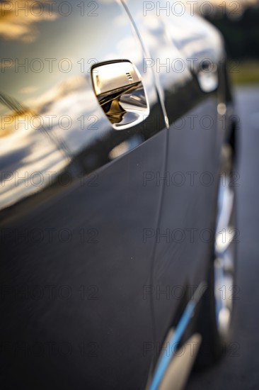 Close-up of a car door with sunset reflections on the paint, BMW i7 electric car, Deer e-Carsharing, Calw, Germany