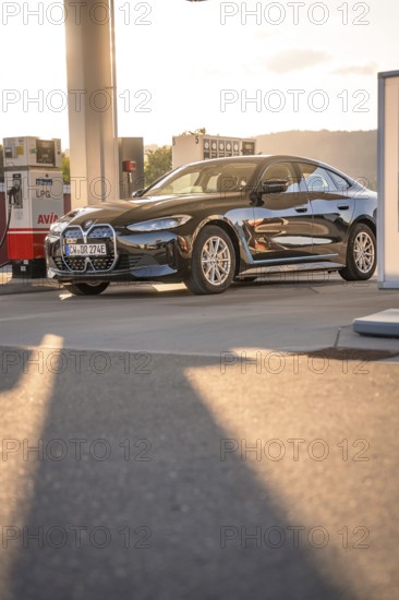 BMW at a gas station with incoming sunlight, BMW i7 electric car, Deer e-Carsharing, Calw, Germany
