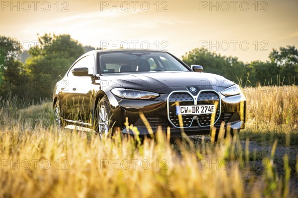 BMW in the field at sunset with natural backdrop, BMW i7 electric car, Deer e-Carsharing, Calw, Germany