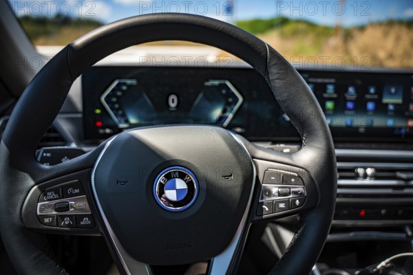The modern steering wheel of a car with tech-heavy dashboard and display, BMW i7 electric car, Deer e-Carsharing, Calw, Germany