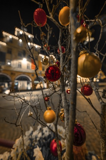 Christmassy decorated tree with balls and lights in a nighttime street scene, Calw, Black Forest, Germany