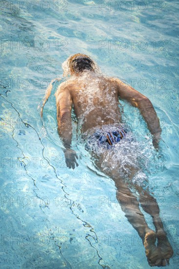 A swimmer dives through the pool and creates dynamic water splashes, Triathlon, Calw, Germany