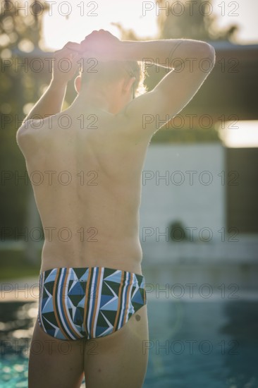Man standing by the pool and feeling the sun on his skin, triathlon, Calw, Germany
