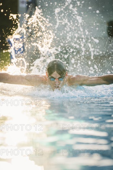 A dynamic moment of a swimmer in the pool with splashes of water in the air, Triathlon, Calw, Germany