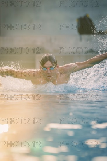 A swimmer wearing sunglasses in the pool shows a powerful swimming movement, Triathlon, Calw, Germany